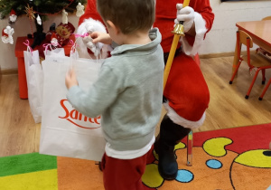 Dziecko odbiera prezent od Mikołaja.